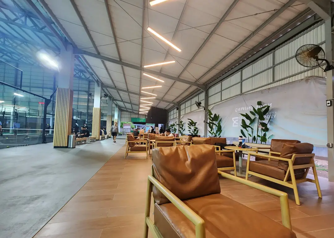 Lounge with leather armchairs beside the courts